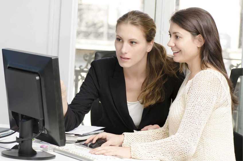 Woman with a teenager looking at a computer.