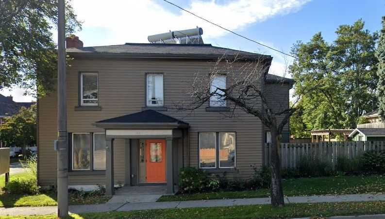 Large two storey house with an orange door.