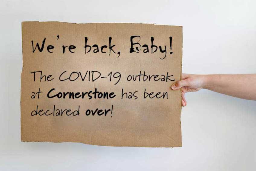 Outstretched hand holding a sign saying We're Back, Baby!